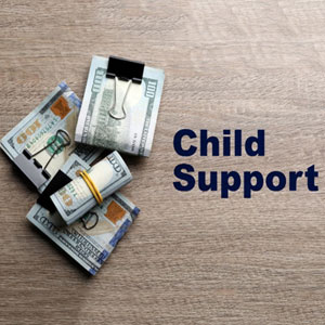 Piles of U.S. dollars on a wooden table with 'Child Support' text, representing Child Support - LAW OFFICES OF JEFFREY M. BLOOM